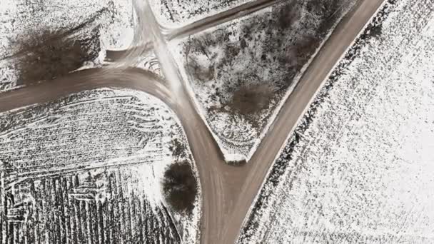 Vista aérea con campo carretera y campos de agricultura arada cubiertos de nieve — Vídeo de stock