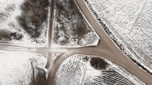 Αεροφωτογραφία με αγροτικό δρόμο και χιόνι καλυμμένα οργωμένα αγροτικά χωράφια — Αρχείο Βίντεο