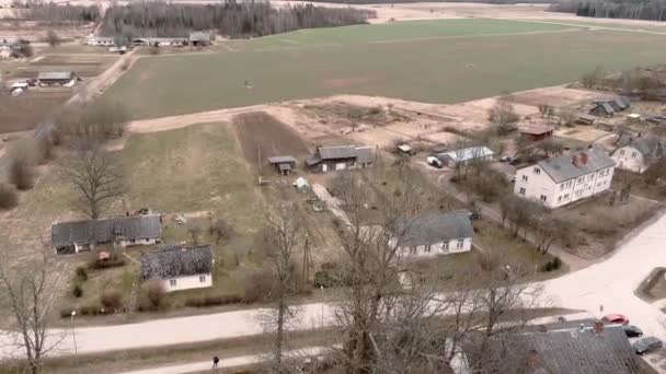 Drohnenflug über der kleinen ländlichen Ortschaft Umurga im Frühling, Lettland — Stockvideo