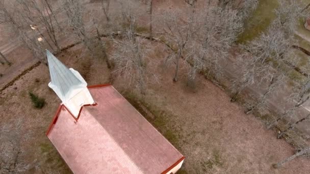 Μικρό χωριό εκκλησία με χρυσό καιρό vane πετεινάρι στην κορυφή του καμπαναριού στην Umurga, Λετονία. Αεροφωτογραφία από μη επανδρωμένο αεροσκάφος — Αρχείο Βίντεο