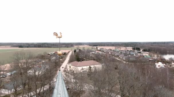 Malý vesnický kostel se zlatým kohoutem na vršku zvonice v lotyšském Umurze. Letecký pohled z dronu — Stock video