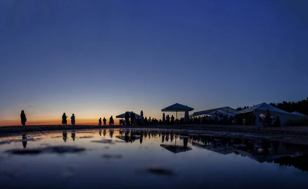 Gün batımında sahil barındaki kalabalık siluetleri — Stok fotoğraf