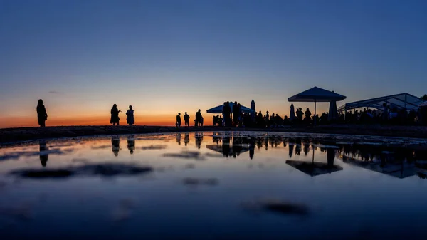 Siluetas de multitud en el bar junto al mar al atardecer —  Fotos de Stock