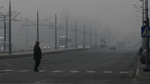 Homme traversant la grande route tôt le matin brumeux — Video