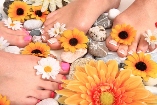 Pedicure nagels, voeten en bloemen — Stockfoto