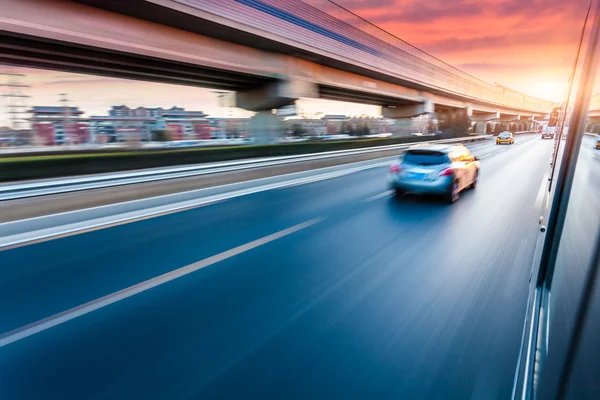 Auto fährt bei Sonnenuntergang auf Autobahn, Bewegungsunschärfe — Stockfoto