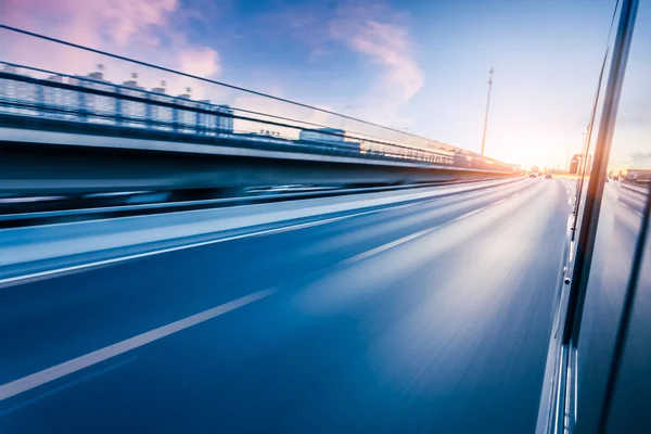 Coche conduciendo en la autopista al atardecer, desenfoque de movimiento — Foto de Stock