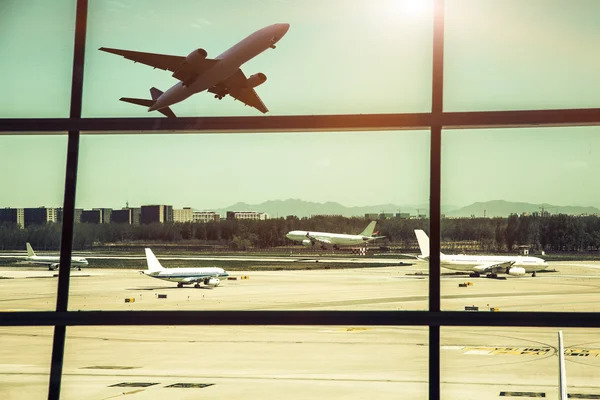 Janelas do aeroporto e avião ao pôr do sol — Fotografia de Stock