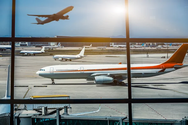 Janelas do aeroporto e avião ao pôr do sol — Fotografia de Stock