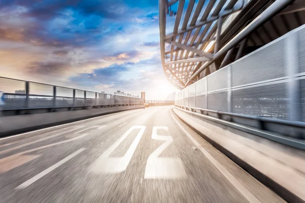 Conducción de coches en la carretera en el fondo de la ciudad, desenfoque de movimiento — Foto de Stock