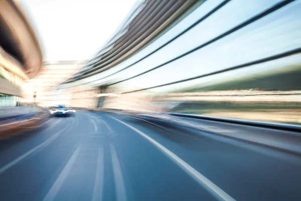 Car driving on road in city background, motion blur — Stock Photo, Image