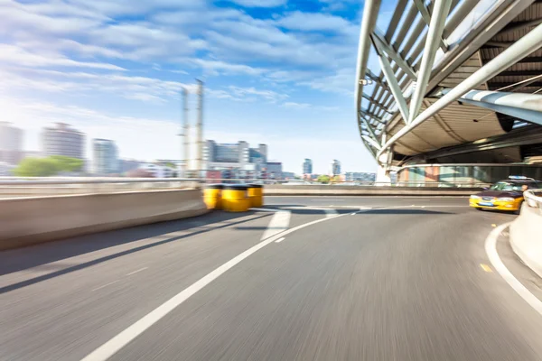 Car driving on road in city background, motion blur — Stock Photo, Image