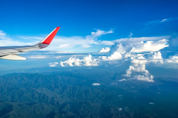 Nubes y cielo visto a través de la ventana de un avión — Foto de Stock