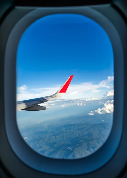 Clouds and sky as seen through window of an aircraft