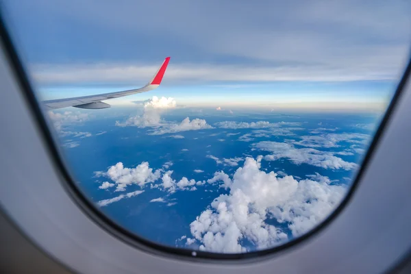 Nuages et ciel vus à travers la fenêtre d'un aéronef — Photo