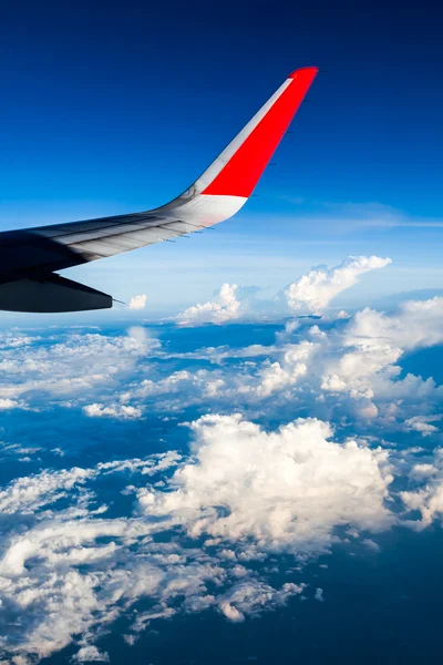 Nubes y cielo visto a través de la ventana de un avión — Foto de Stock