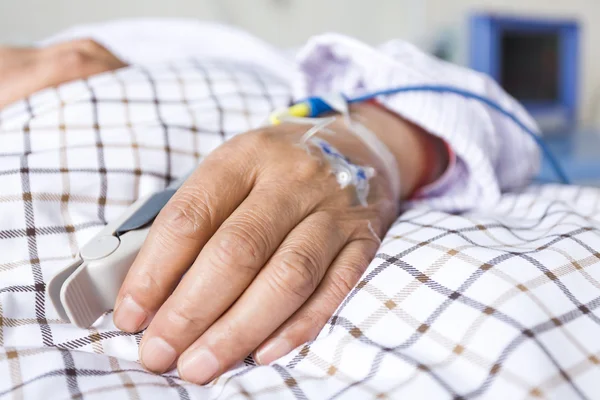 The patient's hand on the bed — Stock Photo, Image