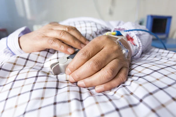 The patient's hand on the bed — Stock Photo, Image