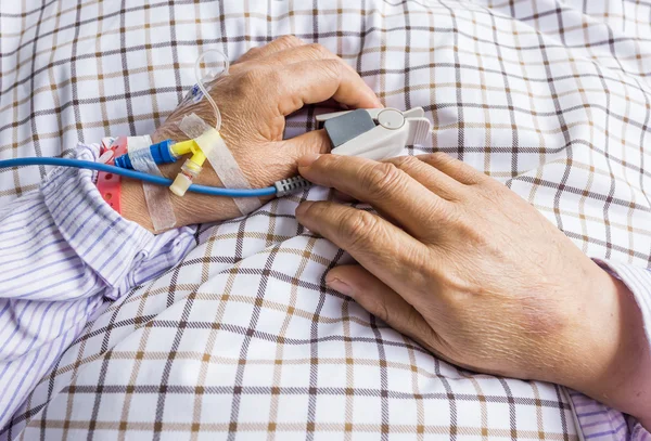 Van de patiënt hand op het bed — Stockfoto