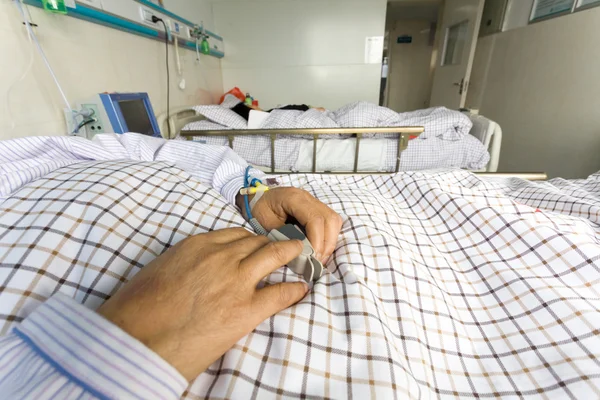 The patient's hand on the bed — Stock Photo, Image