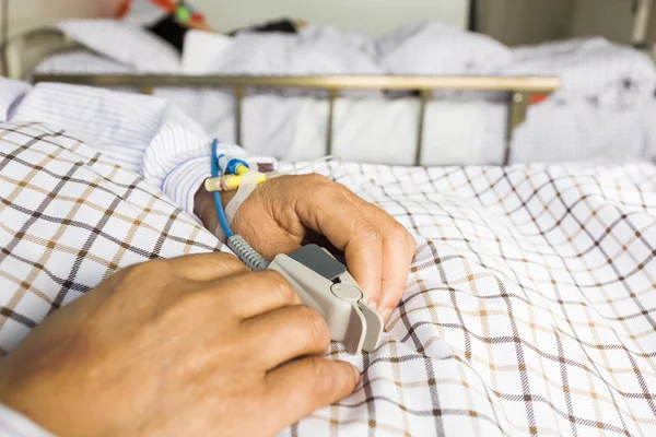 Patientens hand på sängen — Stockfoto