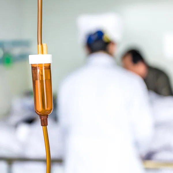 Närbild av infusion flaska med patient och läkare på sjukhus — Stockfoto