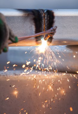 işçi kesme metal meşale kullanarak boru çelik ve yol kenarında yüklemek