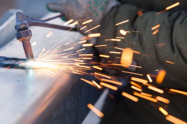 işçi kesme metal meşale kullanarak boru çelik ve yol kenarında yüklemek
