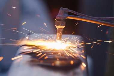 işçi kesme metal meşale kullanarak boru çelik ve yol kenarında yüklemek