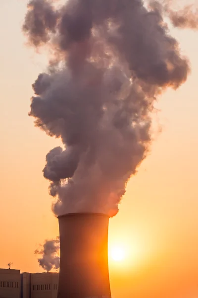 Schoorsteen en koeltorens van elektriciteitscentrale tijdens zonsondergang — Stockfoto