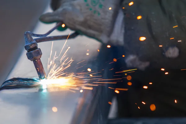 Lavoratore taglio tubo d'acciaio utilizzando torcia metallica e installare bordo strada — Foto Stock