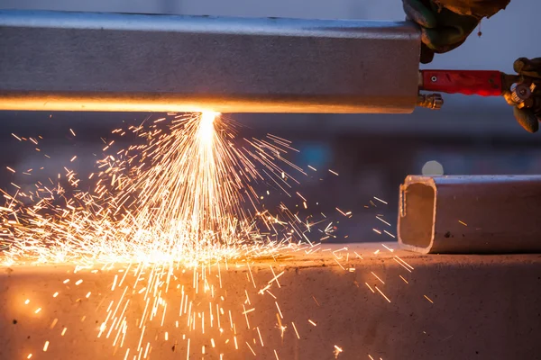 Arbeiter schneidet Stahlrohr mit Metallbrenner und installiert Straßenrand — Stockfoto