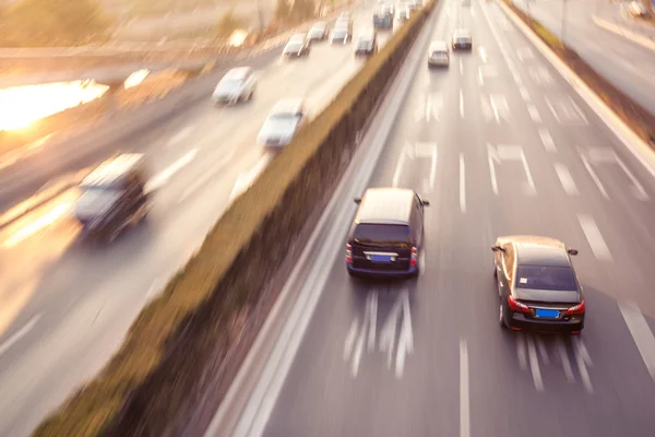 Cars in motion blur on street during sunset — Stock Photo, Image