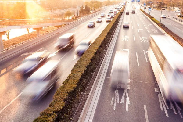 Cars in motion blur on street during sunset — Stock Photo, Image