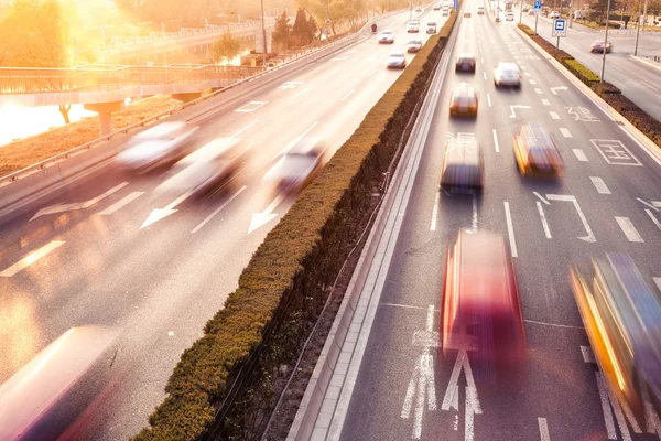 Cars in motion blur on street during sunset — Stock Photo, Image