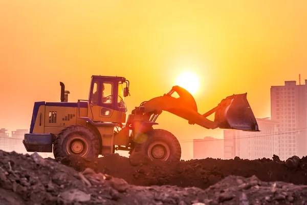 Schwere Radbaggermaschine bei Sonnenuntergang — Stockfoto