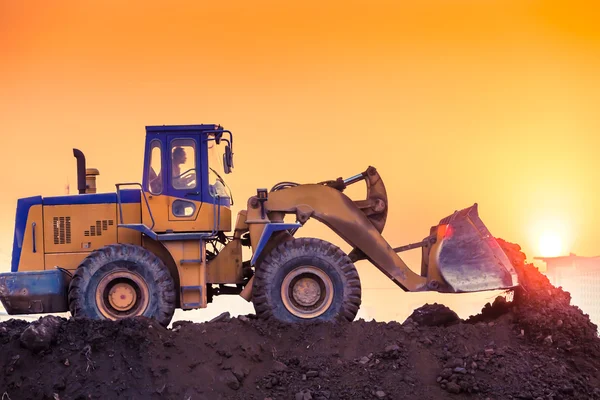 Heavy wheel excavator machine working at sunset — Stock Photo, Image