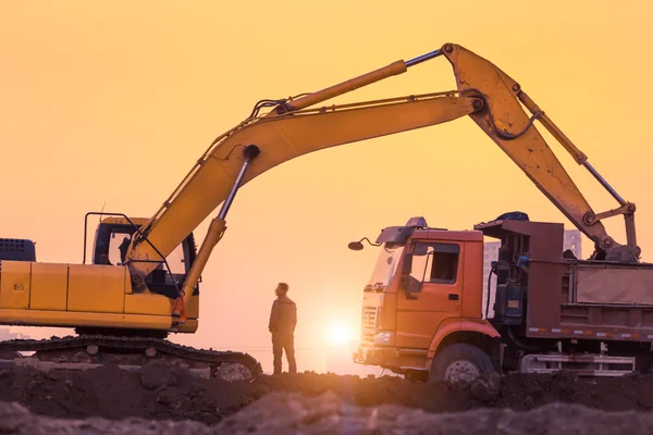 günbatımında çalışan ağır tekerlekli ekskavatör makine