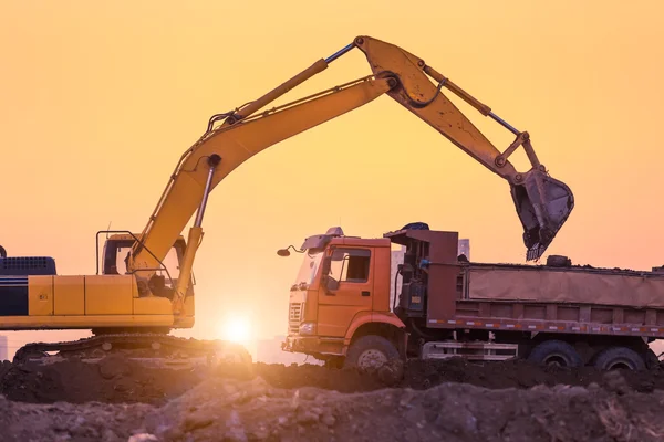 Máquina excavadora de ruedas pesadas trabajando al atardecer —  Fotos de Stock