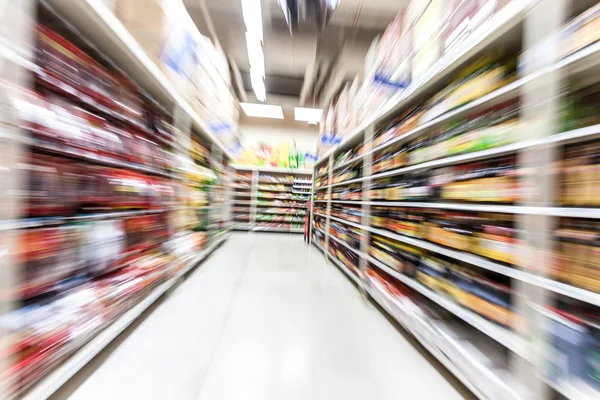 Jovem mulher fazendo compras no supermercado, borrão de movimento — Fotografia de Stock