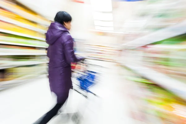 Ung kvinna shopping i snabbköpet — Stockfoto