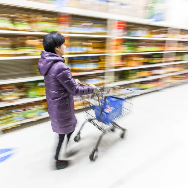 Ung kvinna shopping i snabbköpet — Stockfoto