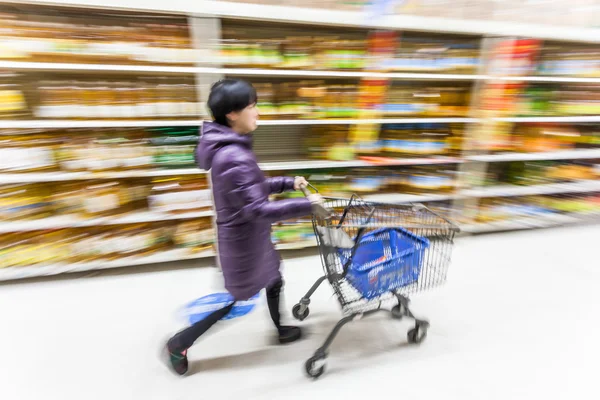 Genç bir kadın süpermarkette alışveriş yapıyor. — Stok fotoğraf