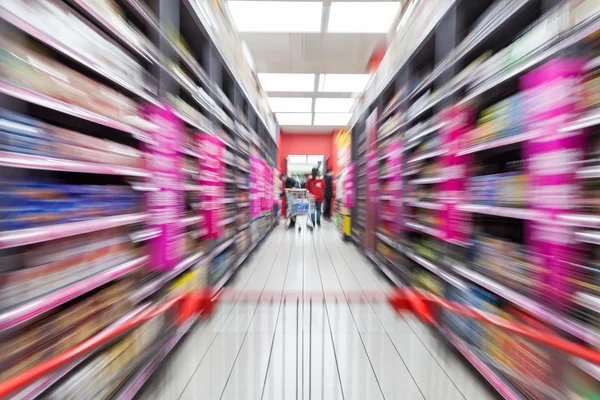 Mladá žena, nakupování v supermarketu, rozmazání pohybem — Stock fotografie