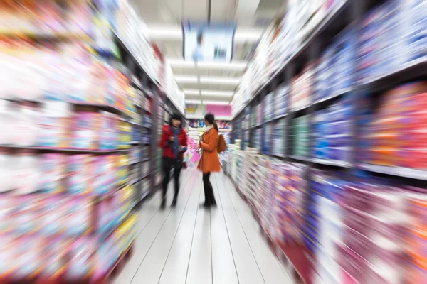 若い女性のモーション ブラー、スーパー マーケットでのショッピング — ストック写真