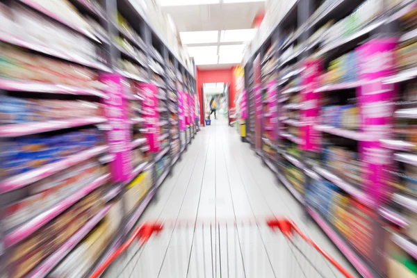 Jonge vrouw winkelen in de supermarkt, bewegingsonscherpte — Stockfoto