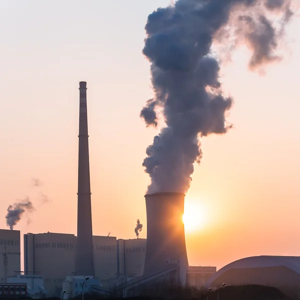 Chaminé e torres de refrigeração da usina elétrica durante o pôr do sol — Fotografia de Stock