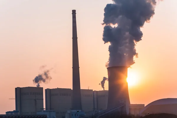 Chaminé e torres de refrigeração da usina elétrica durante o pôr do sol — Fotografia de Stock