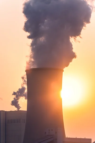 Schoorsteen en koeltorens van elektriciteitscentrale tijdens zonsondergang — Stockfoto