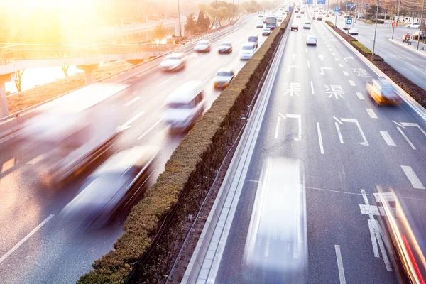 Cars in motion blur on street during sunset — Stock Photo, Image